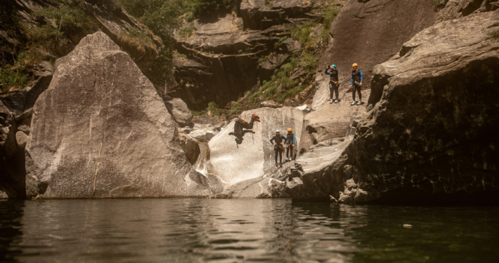 CanyoningBodengo MannmachteinenSaltoinklaresWasserumgebenvonwunderschönemGranit