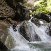 CanyoningEinsteiger MannrutschtfröhlichüberSteineimCanyon